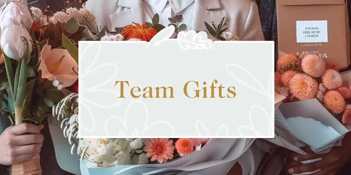 Team Gifts Collection: A person in a white blazer holding vibrant flower bouquets with tulips, dahlias, and other blooms, ready for gifting. Fabulous Flowers and Gifts.