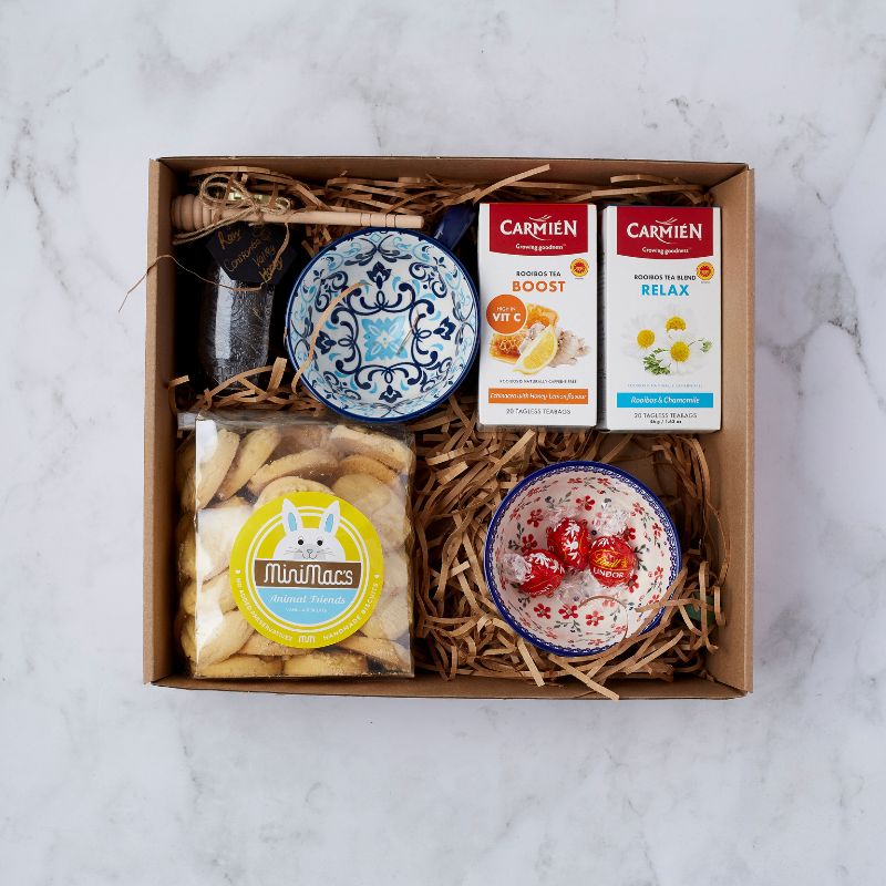 Gift box with rooibos tea, honey, ceramic bowls, biscuits, and Lindt chocolates