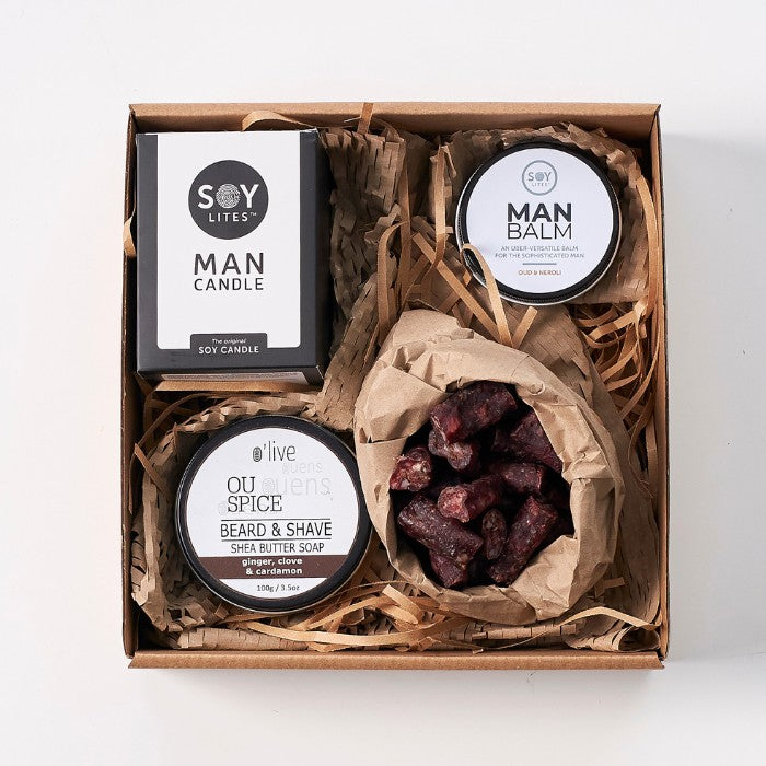 The Essentials Gift Box For Men featuring soy candles, man balm, beard and shave soap, and artisanal dried meat in a rustic presentation box.