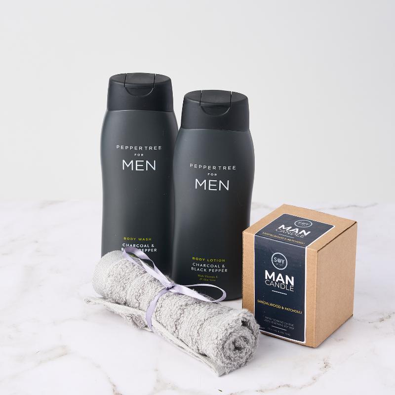 The Gentlemen's Retreat gift set featuring Peppertree body wash, body lotion, and a soy candle for a luxurious men's self-care experience.