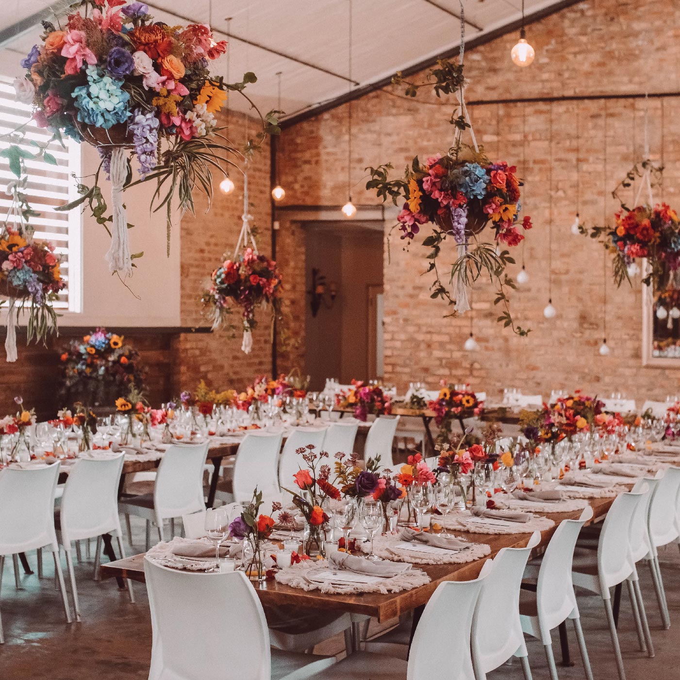 Beautifully decorated wedding venue with hanging floral arrangements and elegant table settings at Fabulous Flowers and Gifts, perfect for weddings, events, and corporate gifting.