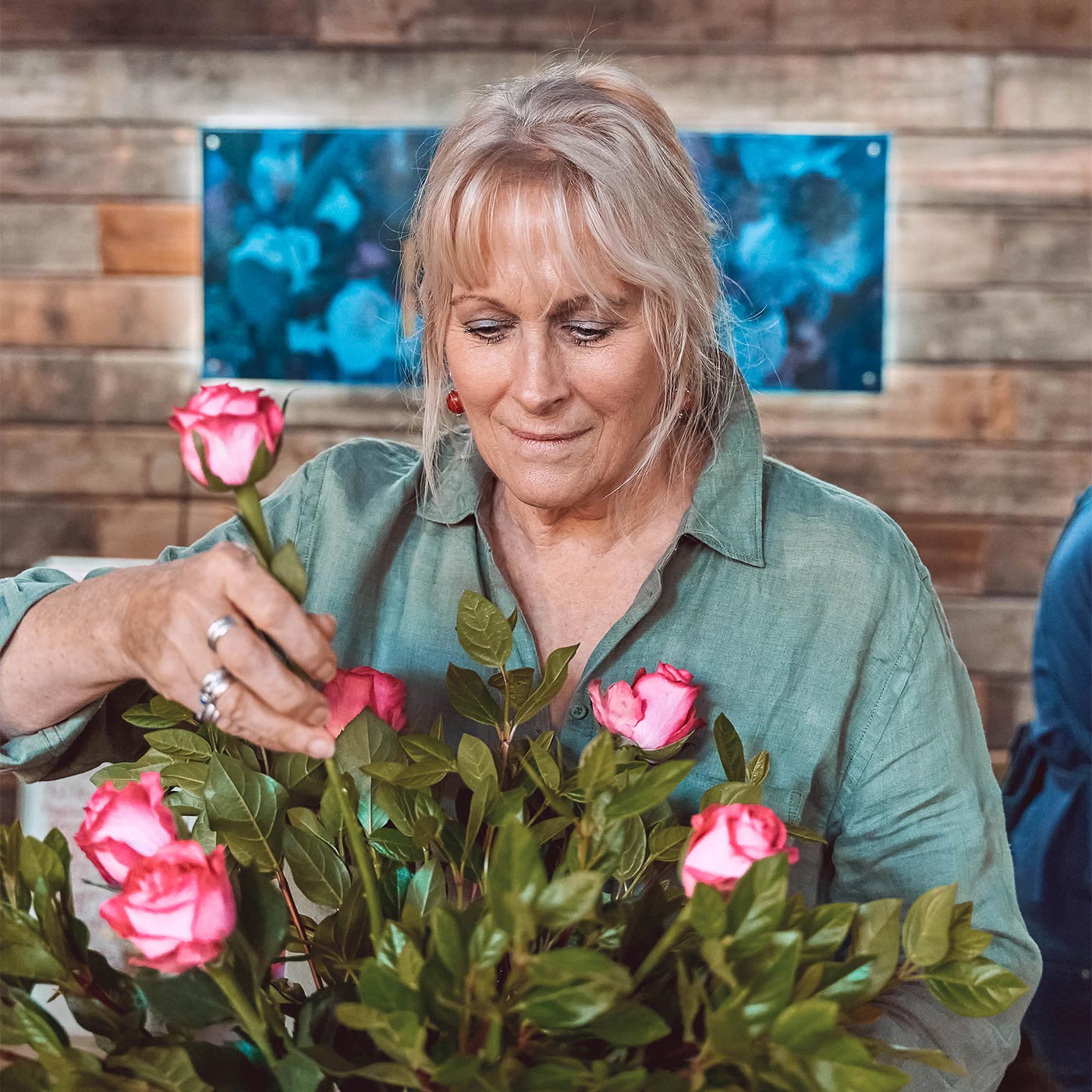 lorist arranging a bouquet of pink roses, highlighting the same-day and nationwide gifting services offered by Fabulous Flowers and Gifts.