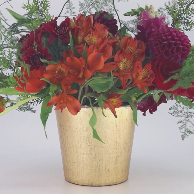 Video with pleasant music of a flower arrangement in a gold container